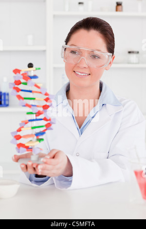 Carino scienziato che mostra la doppia elica del DNA modello Foto Stock