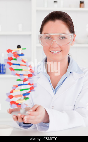 Ritratto di un simpatico scienziato che mostra la doppia elica del DNA modello Foto Stock