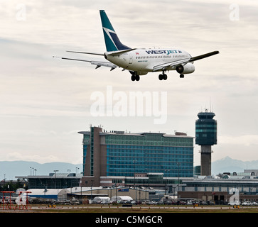 Un Westjet Airlines Boeing 737-600 jet del passeggero è visto come si atterra all'Aeroporto Internazionale di Vancouver. Foto Stock