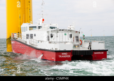 Un recipiente di alimentazione accanto ad una turbina eolica del Walney per centrali eoliche offshore project, off Barrow in Furness, Cumbria, Regno Unito Foto Stock