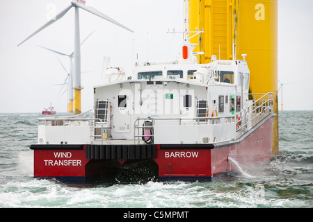 Un recipiente di alimentazione accanto ad una turbina eolica del Walney per centrali eoliche offshore project, off Barrow in Furness, Cumbria, Regno Unito Foto Stock