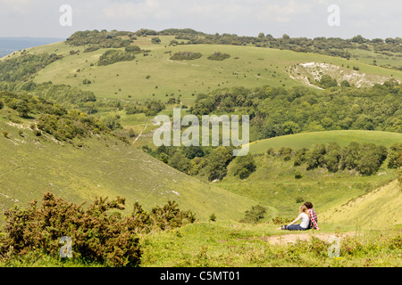 Una giovane coppia sedersi godendo della vista a Devils Dyke vicino a Brighton nel South Downs National Park Foto Stock