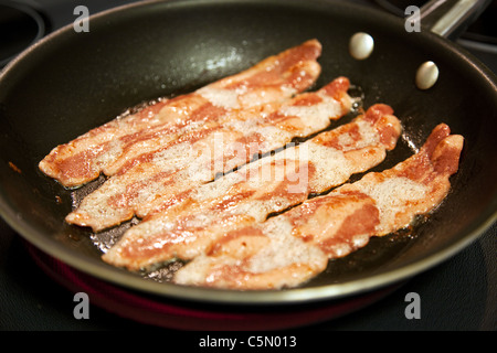 Per la cottura delle fette di sani, a basso contenuto di grassi la Turchia il bacon in una padella. Profondità di campo. Foto Stock