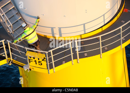 Un pezzo di torre di essere abbassato su una turbina a vento sulla base dell'Walney offshore wind farm, Cumbria, Regno Unito. Foto Stock