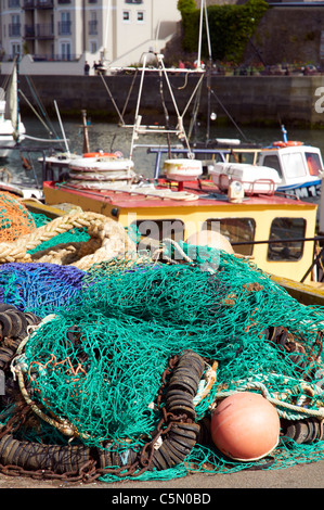 Le reti da pesca, funi e boe impilati sulla banchina a Brixham Harbour, Devon, Inghilterra. Foto Stock