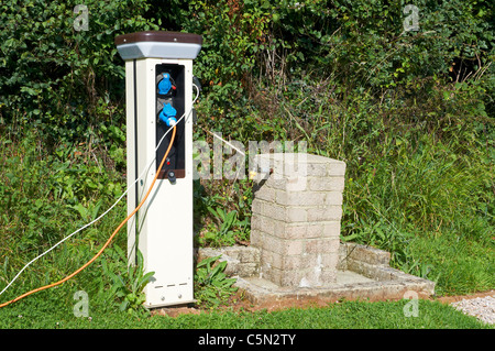 Elettricità bollard (o gancio elettrico) e di approvvigionamento di acqua potabile su un passo serviti su un caravan Club sito nel Devon. Foto Stock