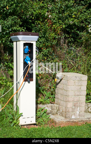 Elettricità bollard (o gancio elettrico) e di approvvigionamento di acqua potabile su un passo serviti su un caravan Club sito nel Devon. Foto Stock