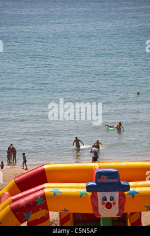 Divertimento in mare a Bournemouth con clown gommoni sulla spiaggia Foto Stock