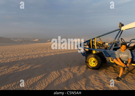 Huacachina Oasis, Ica, il Perù meridionale, driver sandbuggy prendendo una pausa nelle dune al tramonto (Sechura deserto, secondo il WWF) Foto Stock