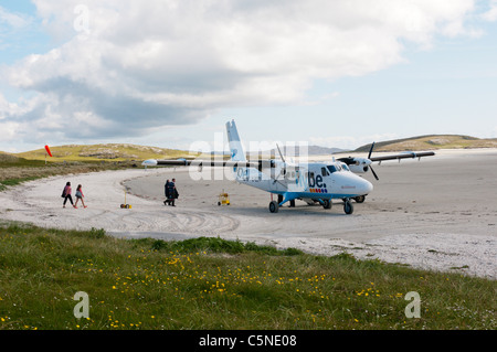 I passeggeri di salire a bordo di un aereo di Flybe - Loganair sulla spiaggia pista di atterraggio per aerei sull'isola di Barra nelle Ebridi Esterne Foto Stock