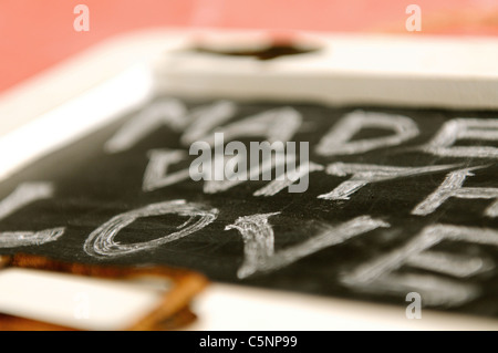 Fatto con amore - scritto con un gessetto su un po' di Blackboard Foto Stock