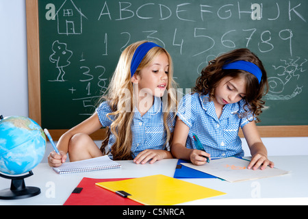 Aula con due bambini studenti barare in esame di prova a scuola Foto Stock