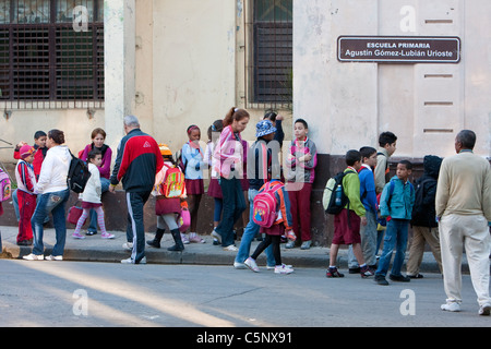 Cuba, La Habana. Cuba giovane generazione. Bambini di scuola elementare di fronte a scuola. Foto Stock