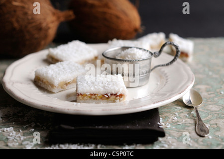 Noce di cocco e fette di ciliegia su una piastra bianca Foto Stock