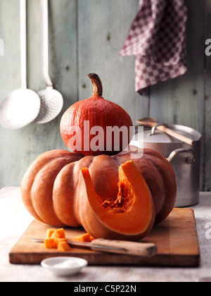 Due diversi tipi di zucche su un tagliere di legno Foto Stock