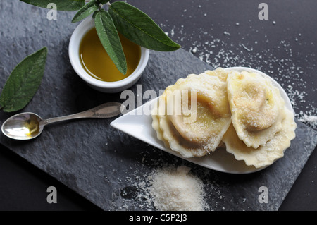 Ravioli di zucca con salvia infuso di olio e abbondante parmigiano grattugiato Foto Stock