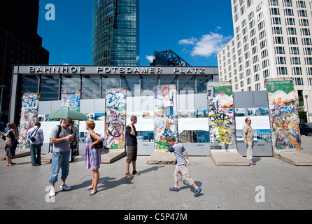 I turisti alla ricerca di sezioni originali del muro di Berlino a Potsdamer Platz a Berlino Germania Foto Stock