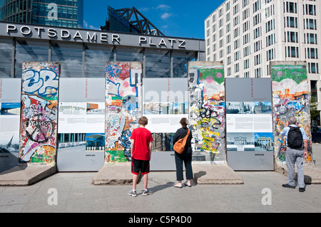 I turisti alla ricerca di sezioni originali del muro di Berlino a Potsdamer Platz a Berlino Germania Foto Stock