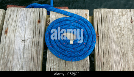 Blu a spirale cima nautica rigging su un pontile in legno. Foto Stock