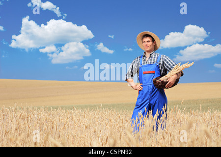 Un agricoltore con cappello di Panama in posa di un campo Foto Stock