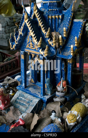 Bellissima ed elaborare in ceramica figurine Buddista sono in mostra in una piccola casa di spirito in un tempio buddista in Thailandia. Foto Stock