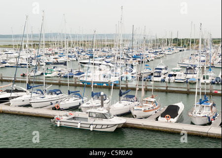 Un certo numero di costosi yacht line-up ormeggiata in un porto vicino a Solent estuario a Lymington, Hampshire. Foto Stock