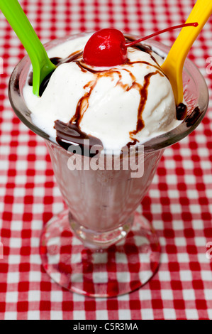 Gelato alla vaniglia e cucchiai con la ciliegia e cioccolato Topping Foto Stock