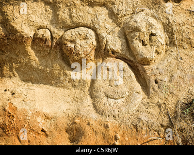 Volti scolpiti lungo tempo fa in solido duna di sabbia sull'isola di Susak,Croazia. Foto Stock