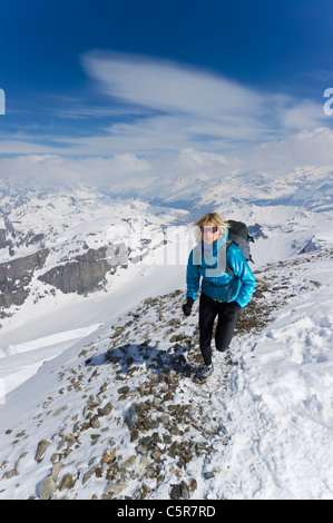 Una donna fare jogging sulle alte montagne Alpine. Foto Stock