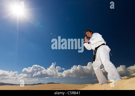 La cintura nera di arti marziali formazione sulle dune del deserto. Foto Stock