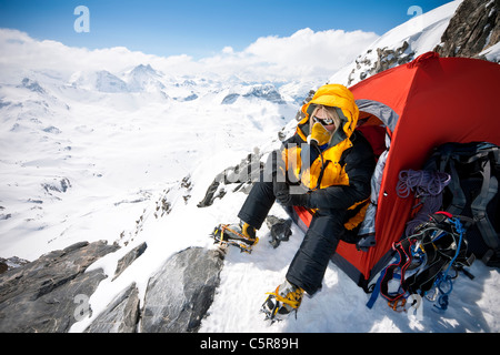 Un alpinista seduto in tenda con mascherina di ossigeno su molto ad alta altitudine. Foto Stock