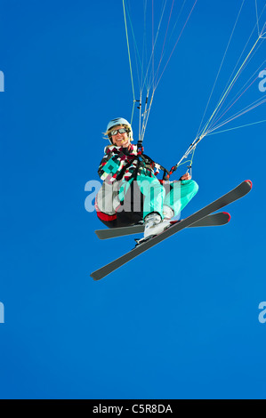 Una femmina di pilota di parapendio sorrisi mentre battenti passato. Foto Stock