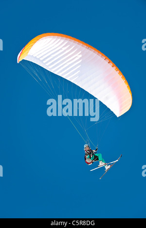 Un inverno Parapendio appassionato di sport sorrisi mentre battenti. Foto Stock