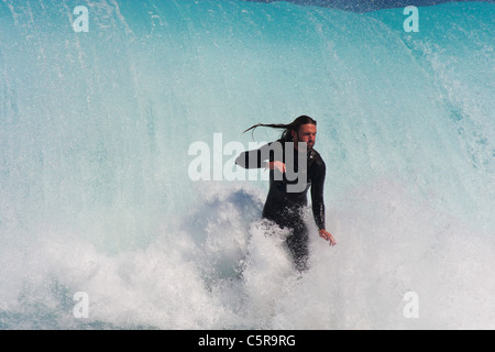 Questo surfer assume un profondo respiro come egli sta per essere portato fuori dalla massiccia ondata dietro di lui. Foto Stock