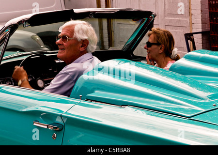 Un 1965 blu pallido Ford Thunderbird convertibile con una coppia matura la guida in esso Foto Stock