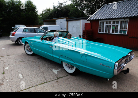 Un 1965 blu pallido Ford Thunderbird convertibile con una coppia matura la guida in esso Foto Stock