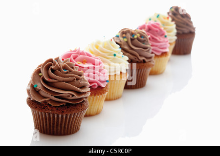 Close up di fragola, vaniglia e crema di burro al cioccolato tortine contro uno sfondo bianco Foto Stock