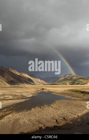 Rainbow e tempestoso cielo sopra il Barmur riolite montagne e il fiume Jokulgilskvisl Landmannalaugar Islanda Foto Stock