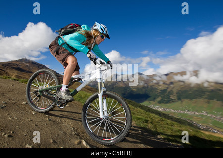 L'Italia, Livigno, vista di donna equitazione mountain bike downhill Foto Stock