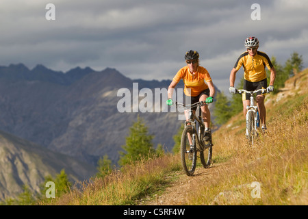 L'Italia, Livigno, la vista di un uomo e di una donna equitazione mountain bike Foto Stock