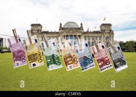 Germania, Berlino, banconote in euro appesi stendibiancheria, Edificio del Reichstag in background Foto Stock