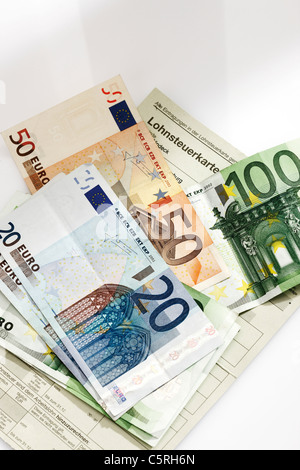 Scheda fiscale, Euro monete e banconote in euro nel pacchetto salariale, vista in elevazione Foto Stock
