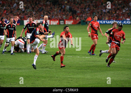 Byron Kelleher tenta di caricare in giù a Ronan O'Gara di kick Foto Stock