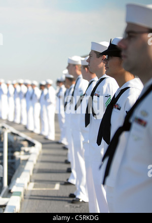 I marinai uomo le rotaie sul ponte di volo della portaerei USS Abraham Lincoln (CVN 72) come la nave tira in Los Angeles Foto Stock