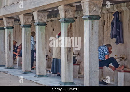 I musulmani lavando loro i piedi prima di entrare nella Moschea, la Moschea Blu, Istanbul, Turchia Foto Stock