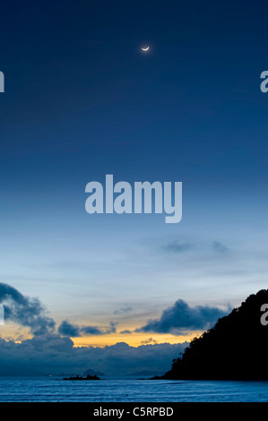 Aumento della luna e del tramonto combinati da un'isola in Tailandia Foto Stock