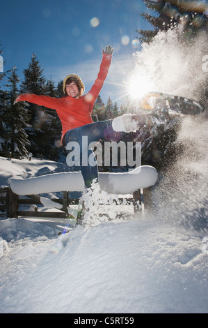 L'Austria, paese di Salisburgo, Flachau, giovane donna che indossa scarpe di neve il salto nella neve Foto Stock