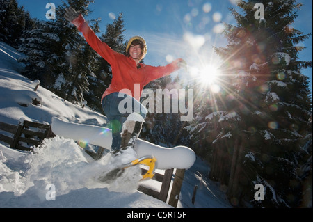 L'Austria, paese di Salisburgo, Flachau, giovane donna che indossa scarpe di neve il salto nella neve Foto Stock