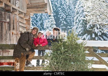 L'Austria, paese di Salisburgo, Flachau, Famiglia appoggiata sulla recinzione in neve Foto Stock