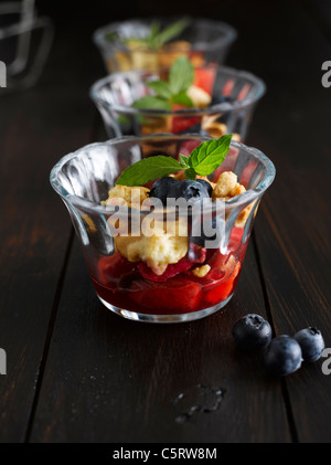 Close up di fragole crumble con mirtilli in recipiente di vetro Foto Stock